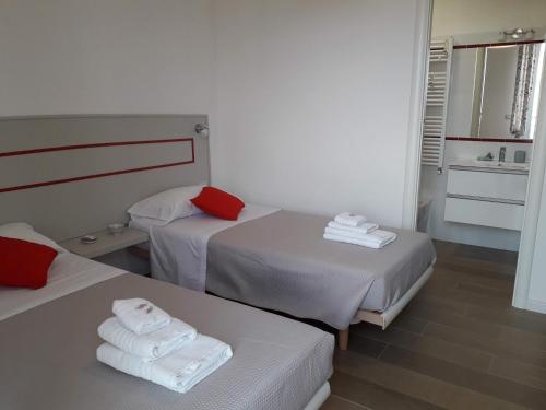 a hotel room with two beds and a sink at Jolie Julie Accomodation in Sassari
