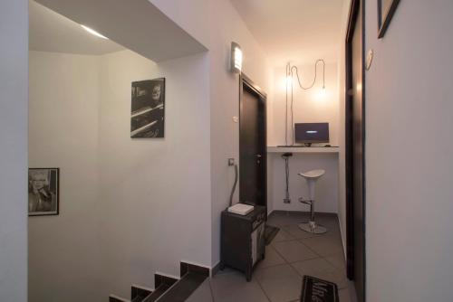 a hallway with a staircase with a television and a desk at Il Taschino Suite in Naples