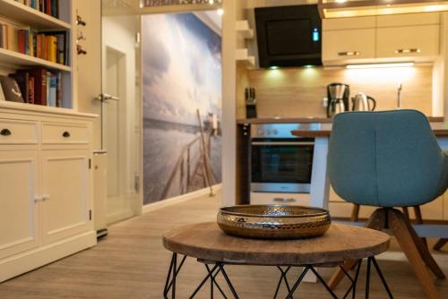 a kitchen with a blue chair and a table at Hotel Stadt Cuxhaven in Cuxhaven