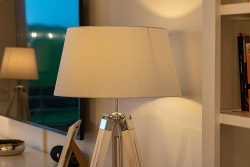 a lamp with a white lamp shade on a table at Hotel Stadt Cuxhaven in Cuxhaven