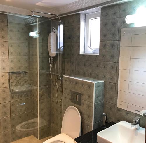 a bathroom with a shower and a toilet and a sink at Progressive Park Hotel in Nairobi