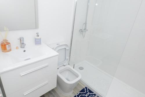 y baño con aseo, lavabo y ducha. en Edifico Baia Apartment, en Funchal