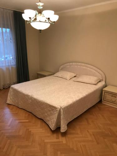 Schlafzimmer mit einem Bett und einem Kronleuchter in der Unterkunft Gábor Pál 1 Apartman 2 szoba in Dunaföldvár