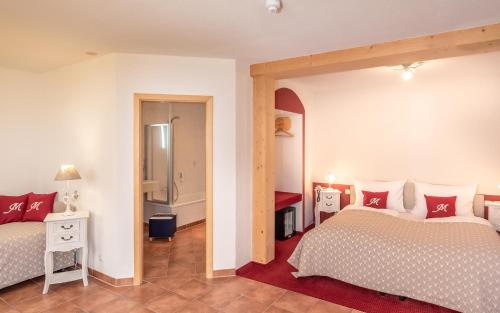a bedroom with two beds and a mirror at Hotel Mutz Garni in Inning am Ammersee