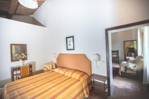 a bedroom with a bed and a chair and a mirror at Agriturismo diffuso Tenuta Armaiolo - widespread farmhouse in Rapolano Terme