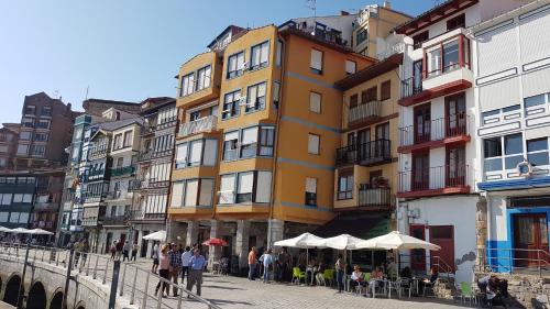 eine Gruppe von Personen, die vor einem Gebäude stehen in der Unterkunft Apartamento Puerto deportivo in Bermeo