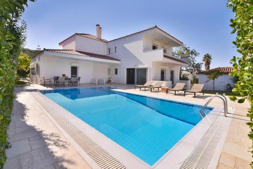 a swimming pool in front of a villa at Villa Noa in Anavissos