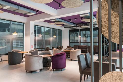a lobby with tables and chairs and purple ceilings at High Cloud Motel in Tainan