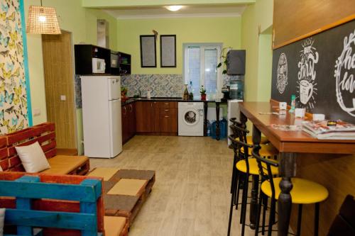 uma cozinha com um frigorífico e uma mesa num quarto em Capsularhouse Hostel em Dnipro