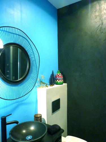 une salle de bain avec un lavabo et un miroir au mur dans l'établissement La Maison narbonnaise, à Narbonne