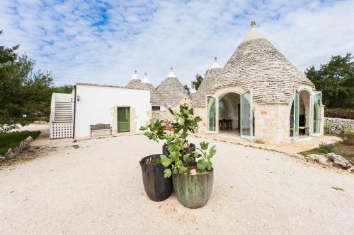 a small house with a straw roof at Trulli Masseria Donno Santo in Ceglie Messapica
