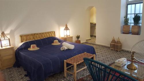 a bedroom with a blue bed with hats on it at Art Riad Au Bord De La Mer in El Jadida