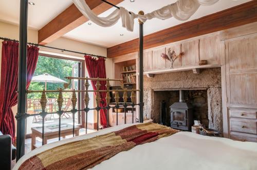 1 dormitorio con 1 cama y chimenea en Cadleigh Manor, en Ivybridge