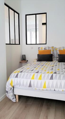 - une chambre avec un grand lit et une couette jaune et blanche dans l'établissement Le P'tit Atelier, Terrasse privative, à Lorient