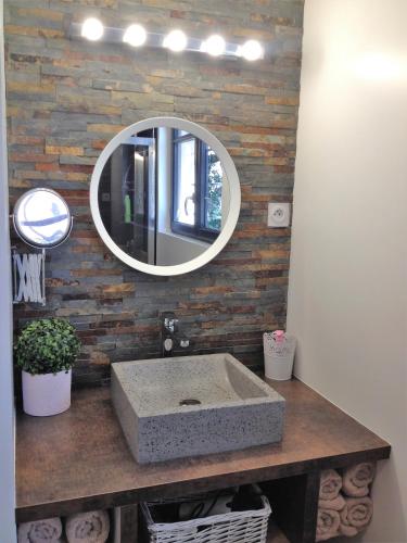 une salle de bain avec un lavabo et un miroir dans l'établissement AU VIEUX LAVOIR avec Parking privé, Jardin , Climatisation, à 500 m de la cité, à Carcassonne