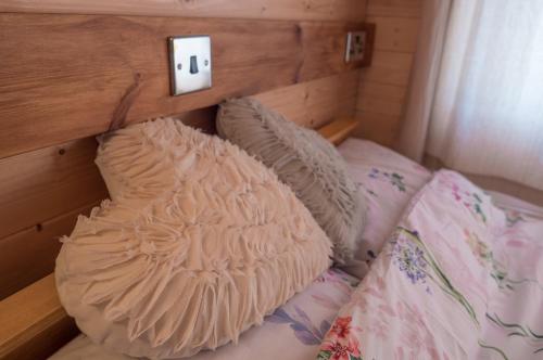 a bed with a wooden headboard and pillows on it at Enlli Fach cabin sleep's 2 adults and 2 children 2 dogs welcome not suitable for contract workers due to parking height restrictions in Borth