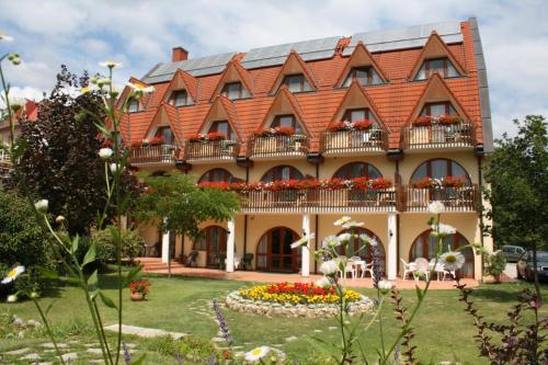 a large house with a balcony and a garden at Ágnes Hotel in Hévíz