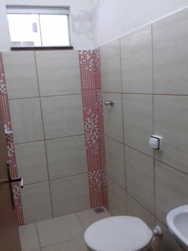 a bathroom with a shower with a toilet and a window at Pouso D' Braga in Pirenópolis