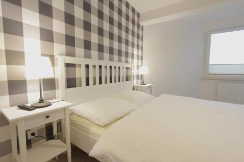 ダルウフコにあるBaltic Korona Apartamenty D17のベッドルーム1室(ベッド1台、ランプ付きテーブル付)