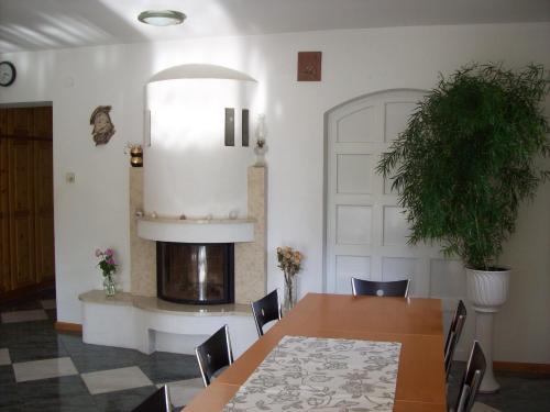 uma sala de jantar com uma mesa e uma lareira em Perge Üdülövilla em Balatonszárszó