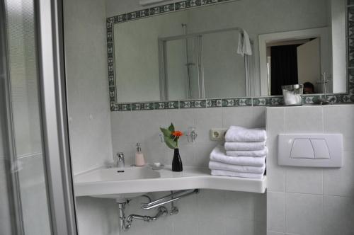 a bathroom with a sink and a mirror and towels at Haus Erli in Mittenwald