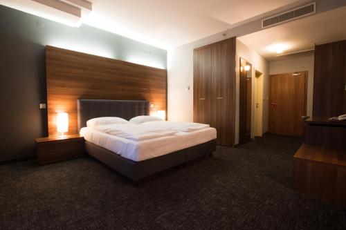 a bedroom with a large bed with a wooden headboard at Hotel Sliško in Zagreb
