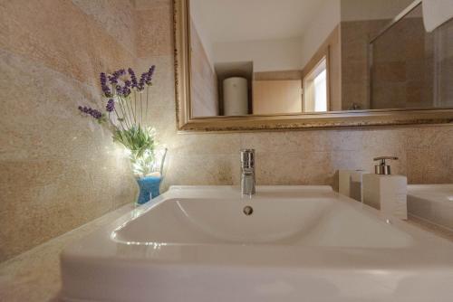 a white sink in a bathroom with a mirror at After All in Mandre