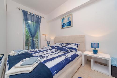 a bedroom with a blue and white bed and a window at After All in Mandre