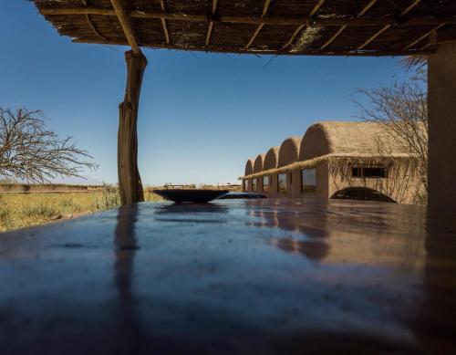 a view from the inside of a building with a thatch roof at Planeta Atacama Lodge in San Pedro de Atacama