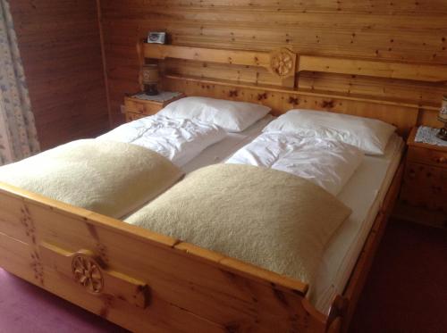 two twin beds in a room with wooden walls at Haus Elsa in Ramsau am Dachstein