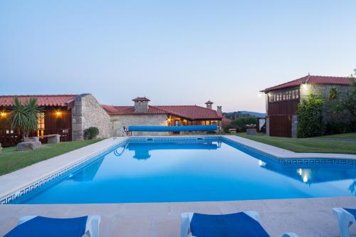 a swimming pool with chairs and a house at Casa de Sequiade in Sequeade
