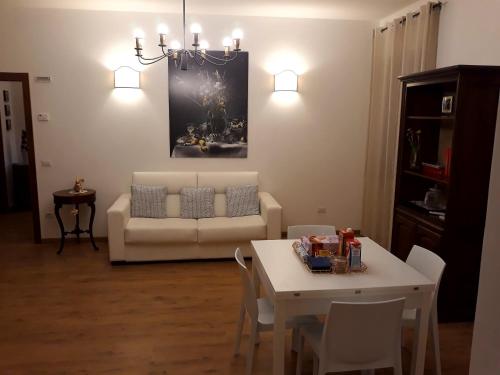 a living room with a couch and a table with chairs at Suite Umberto I in Assisi