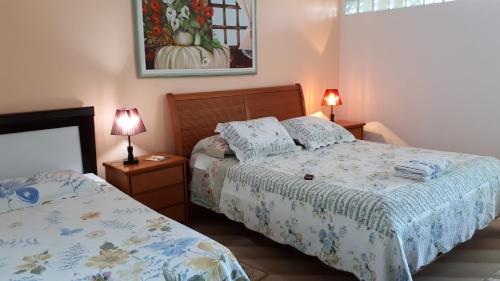 a bedroom with two beds and two lamps in it at Residência Familiar in Campinas