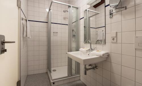 La salle de bains est pourvue d'un lavabo et d'une douche. dans l'établissement Hotel Krone Zentrum, à Vaihingen-sur-l'Enz