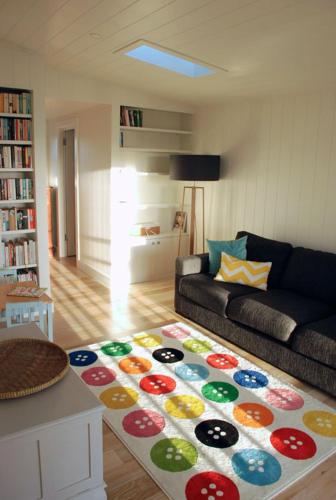 a living room with a couch and a colorful rug at Bluebell in Forster
