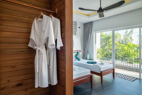 a room with a bed and a robe on a wall at Pippali Boutique Hotel in Kampot