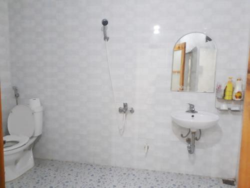 ein Badezimmer mit einem WC, einem Waschbecken und einem Spiegel in der Unterkunft FarmStay Ô A Pháo - km37 Hàm Yên in Tuyên Quang