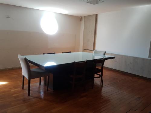 una mesa y sillas en una habitación vacía en Hostel Orla de Tambaú, en João Pessoa