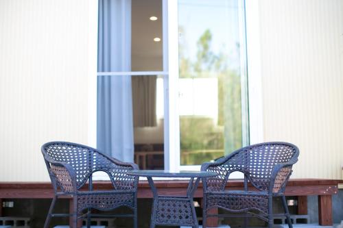 two chairs and a table on a porch at Irie House Fuchaku in Onna