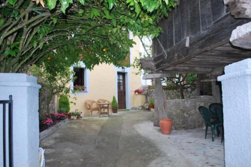 un patio al aire libre con sillas y un naranjo en La Casina de Mon en Quintana de Llanes