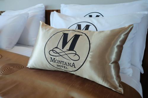 a couple of pillows on a bed with the monogrammedmt at Montana Hotel Songkhla in Songkhla