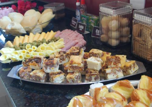 a buffet of food with cheese and other foods at Pousada Orla dos Corais in Maragogi