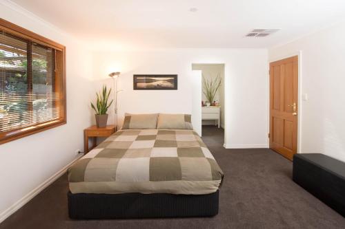 um quarto com uma cama e uma janela em A Suite Spot in the Hills em Mount Barker