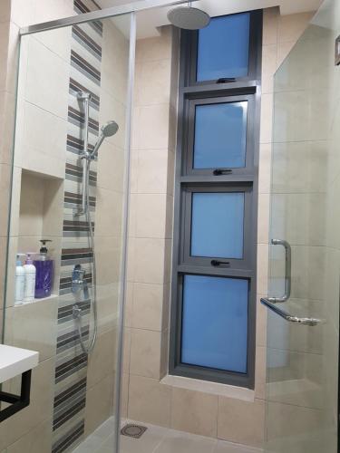 een badkamer met een douche en een glazen deur bij Robertson by MiRic in Kuala Lumpur