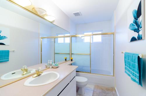 ein Badezimmer mit einem Waschbecken, einem WC und einem Spiegel in der Unterkunft Great Guest Suite in a Gorgeous House in New Westminster