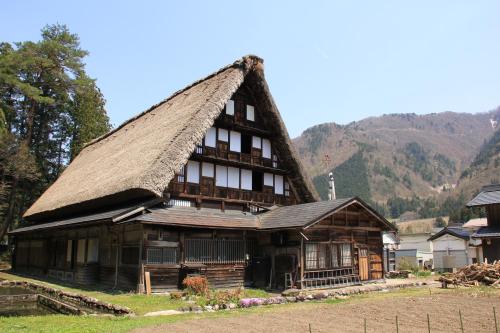 a large wooden house with a thatched roof at Gokayama Onsen Akaokan in Nanto
