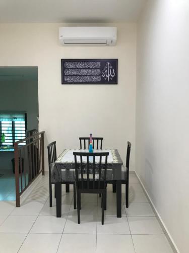a dining room with a black table and chairs at Rumah Melaka in Melaka