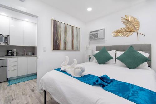 a bedroom with a bed with two stuffed animals on it at Cozy apartment wsteps to beach boardwalk in Hollywood