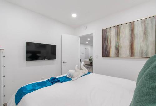 a white bed with a stuffed animal on top of it at Cozy apartment wsteps to beach boardwalk in Hollywood