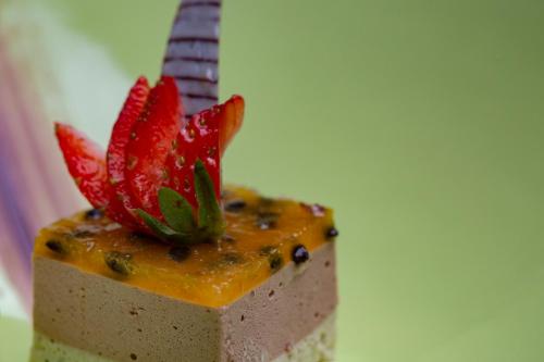 a piece of cake with a red flower on top at Ayana Sea in Wadduwa